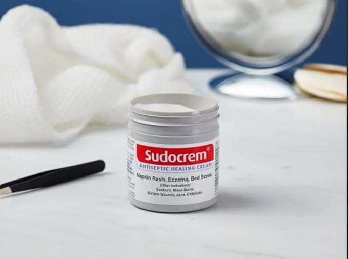 Sudocrem jar on a white surface with a blue background